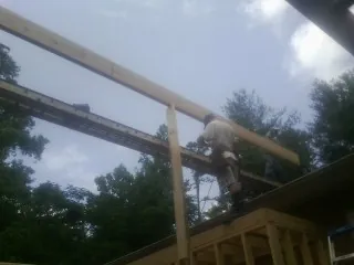 Carpenter setting a ridge beam over a new addition frame — Ice Dam Removal by Roofing Brothers in Columbia Station