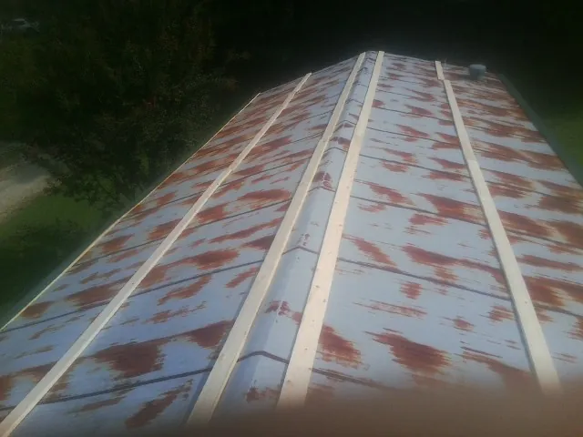 Rusted metal roof panels with new wood purlins before replacement — Storm Damage Roof Repair in Columbia Station by Roofing Brothers