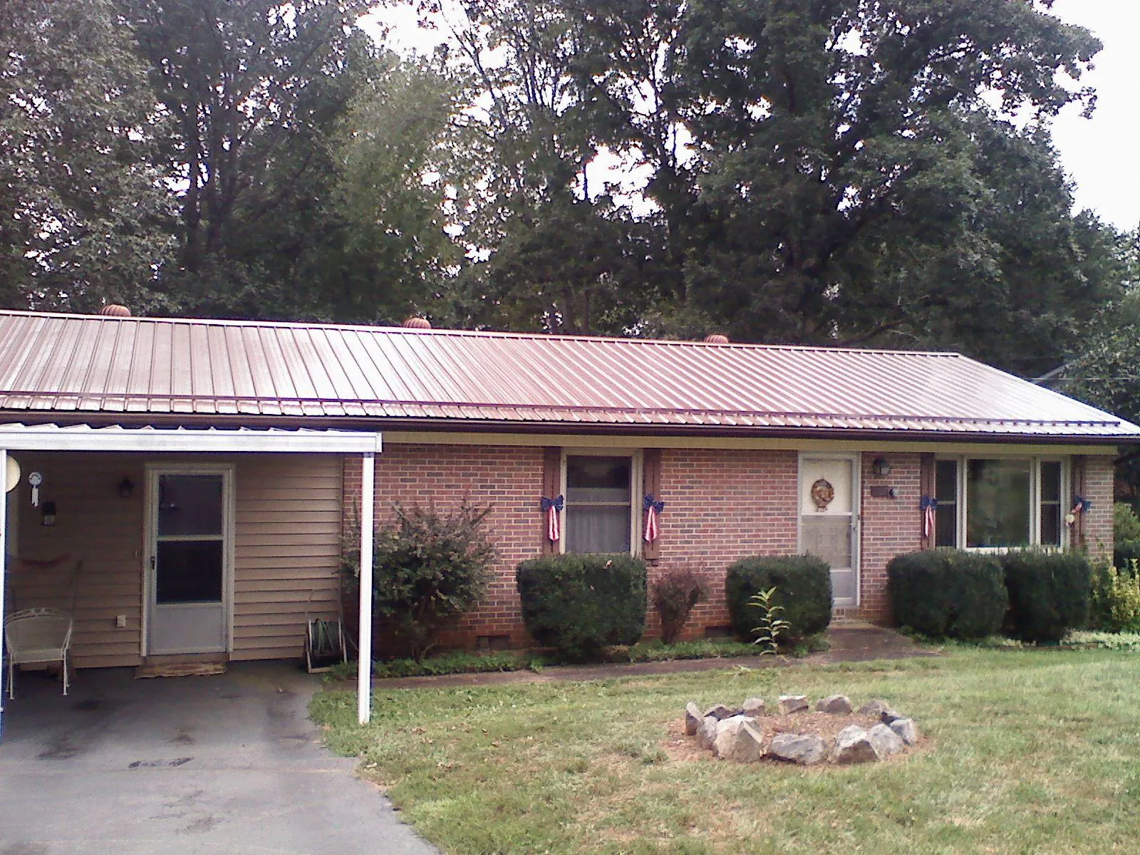 Bronze metal roof and carport on a brick ranch home — Roof Repair work by our crew in Columbia Station